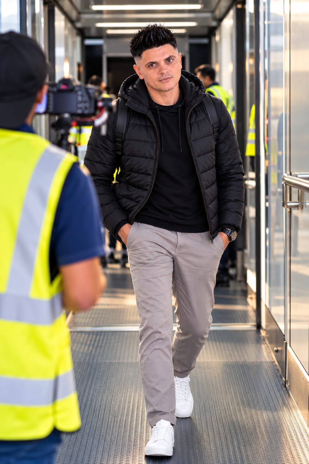 Jean-Pierre Whittingstall in a black jacket, walking towards a camera crew on location